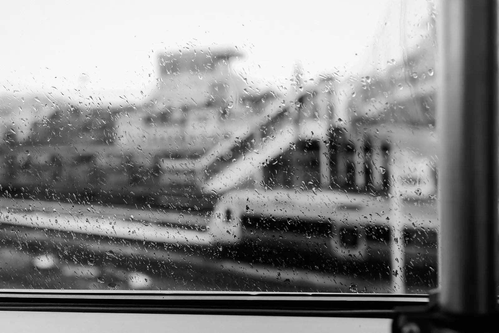 A train station seen through a rain-streaked window, out of focus. Photo by Jordan Ryskamp.