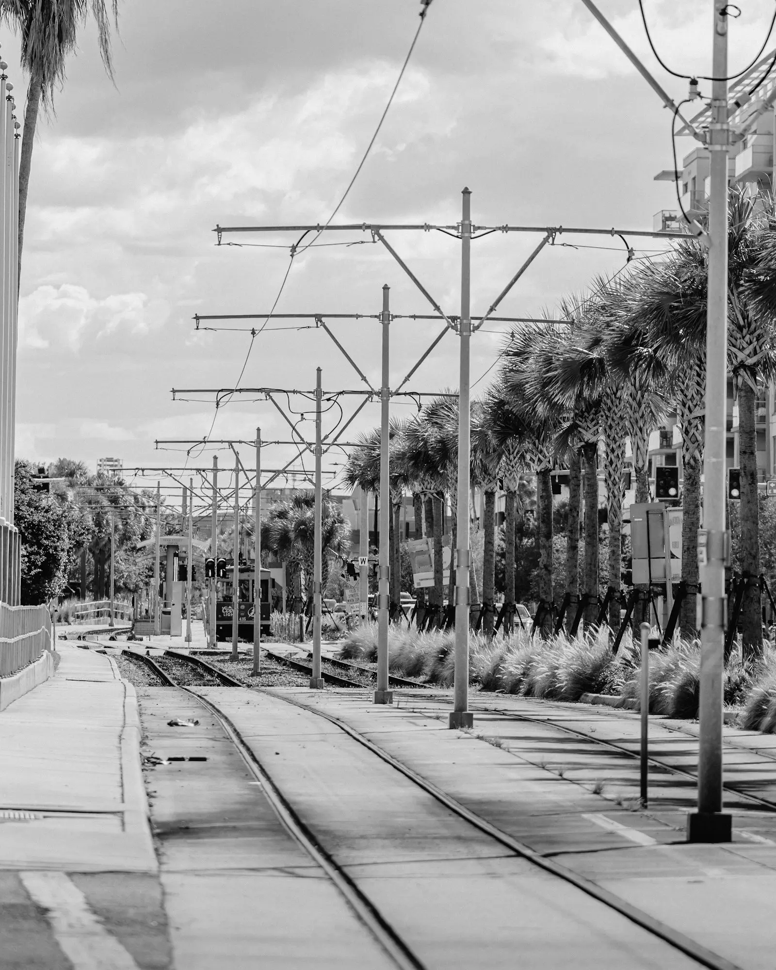 Tram tracks running straight down a street under evenly spaced poles. Photo by Jordan Ryskamp.
